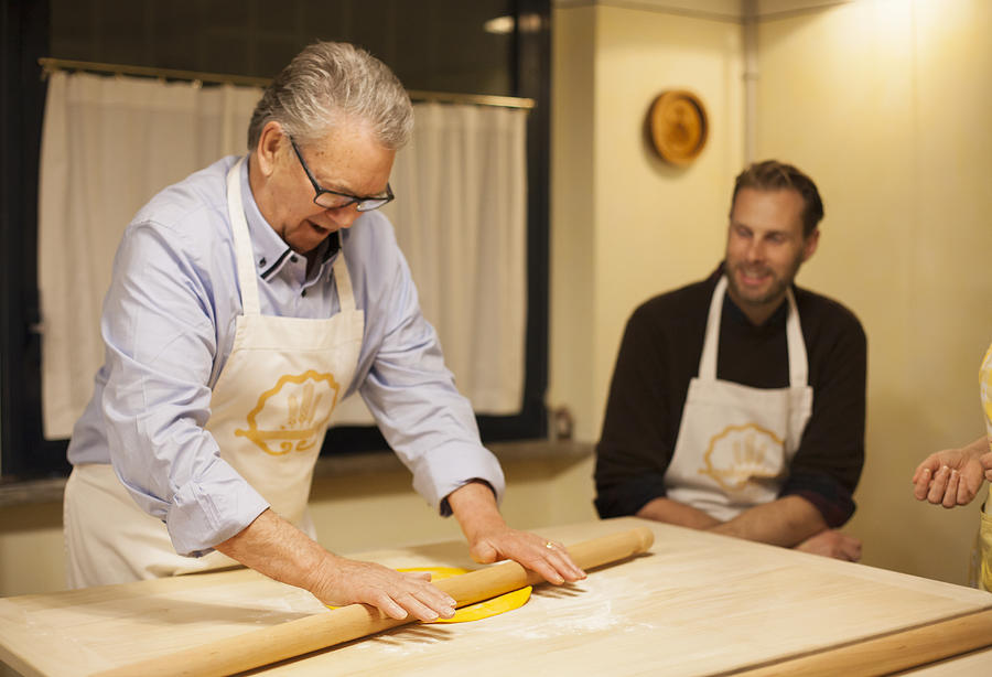 At Italian cooking school: Senior man rolling out dough using rolling pin #1 Photograph by Kathrin Ziegler