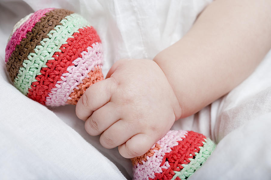 Baby girl holding rattle #1 Photograph by Image Source
