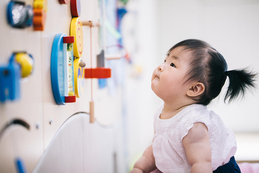 Baby girl playing with toys in a playroom #1 Photograph by Insung Jeon