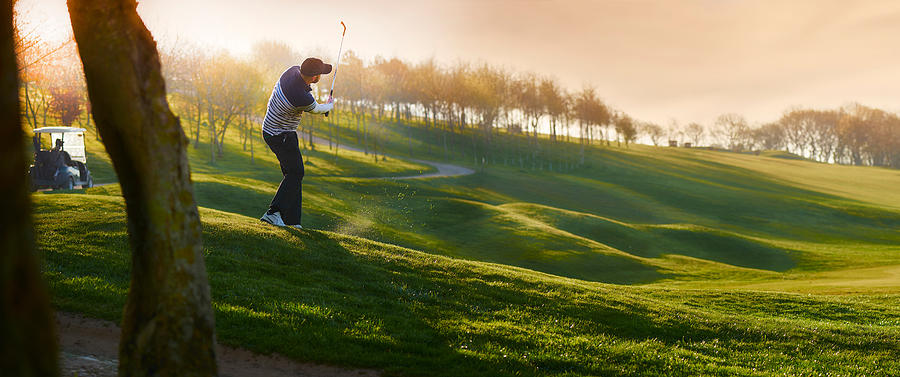 Backlit Golf Course With Golfer Chipping Onto Green #1 Photograph by Sturti