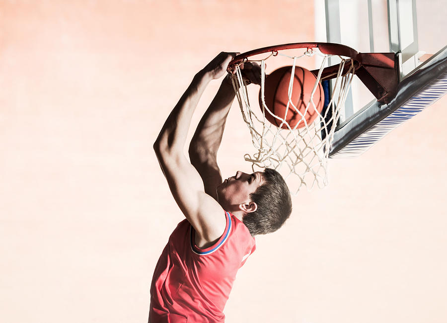 Basketball player slam dunking the ball. #1 Photograph by Skynesher