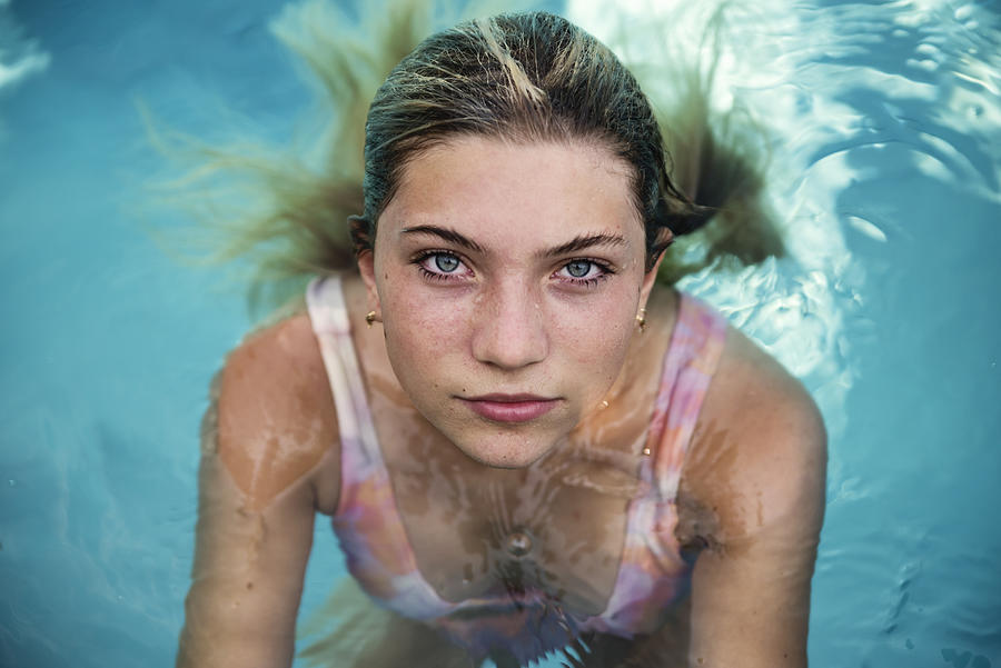 Beautiful portrait of teenage girl in pool water. #1 Photograph by Martinedoucet