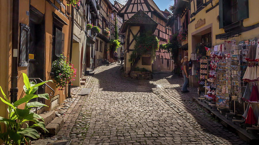 Beautiful view of charming street scene with colorful houses in the historic town of Eguisheim on an idyllic sunny day with blue sky and clouds in summer #1 Photograph by Karlaage Isaksen