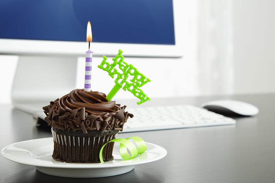 Birthday cupcake on desk #1 Photograph by Vstock