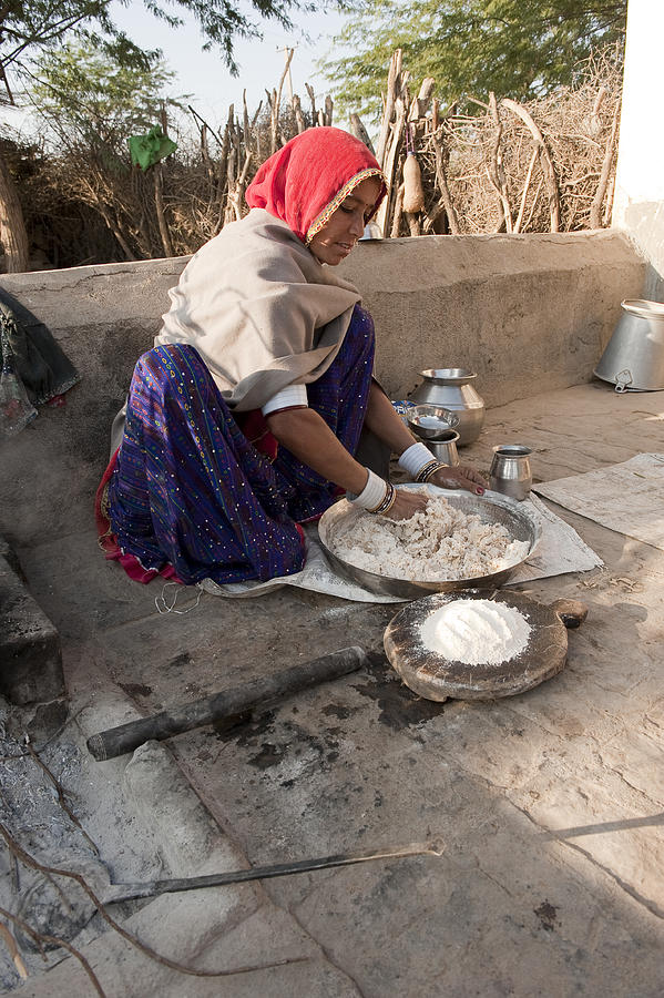 Bishnoi woman making roti (bread) in traditional way, Rajasthan, India #1 Photograph by Mike Powles