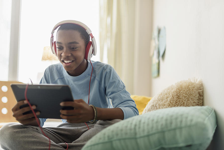 Black boy in headphones using digital tablet #1 Photograph by JGI/Tom Grill