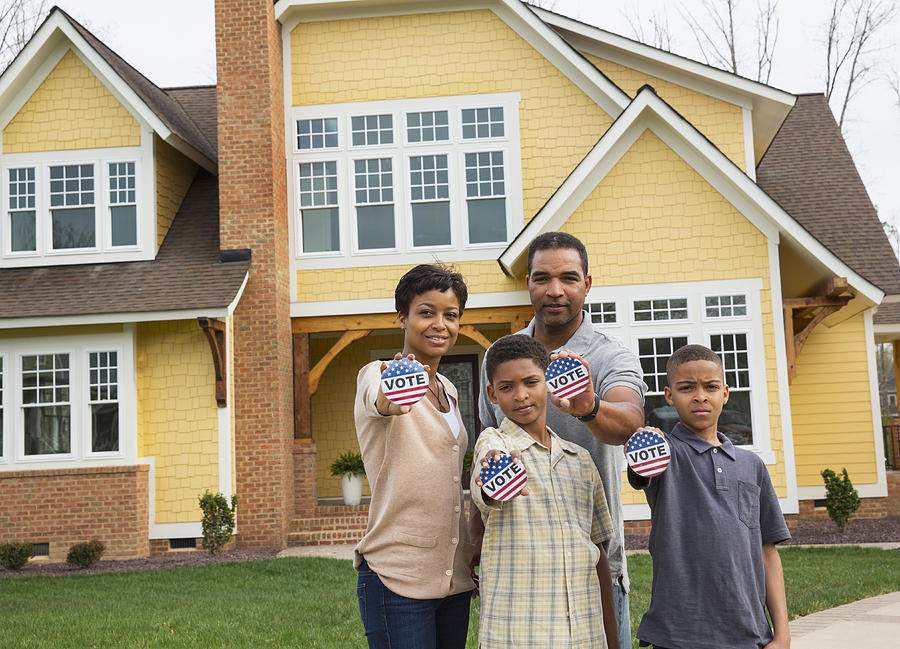 Black family holding Vote buttons outside home #1 Photograph by Ariel Skelley