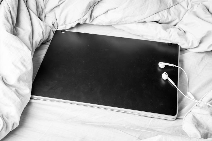 Black laptop on the bed #1 Photograph by Arto_canon
