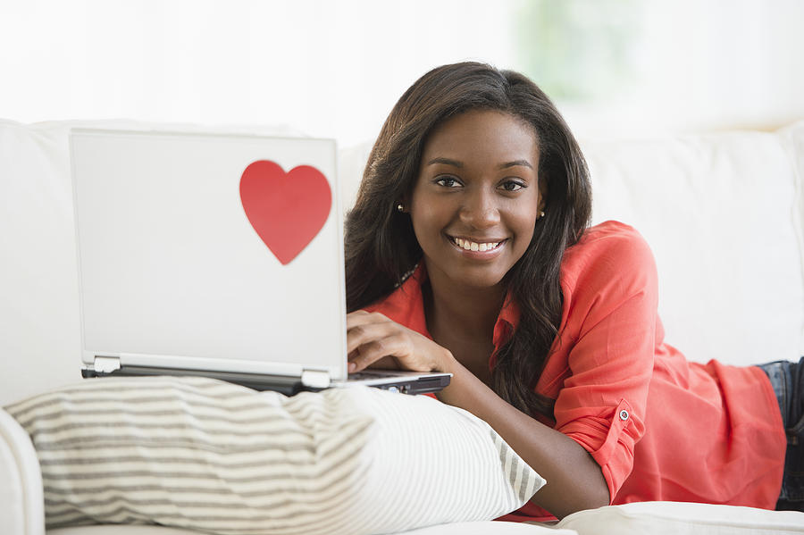 Black woman using laptop on sofa #1 Photograph by JGI/Jamie Grill
