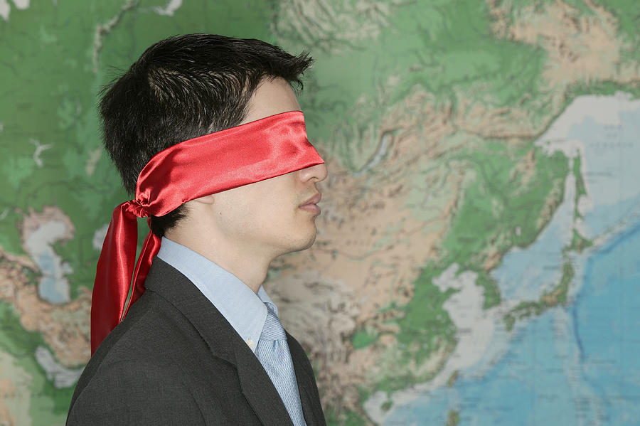 Blindfolded businessman in front of world map #1 Photograph by Comstock Images