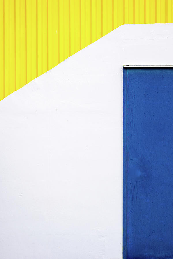 Blue close metal door on a white and yellow wall. Photograph by Michalakis Ppalis