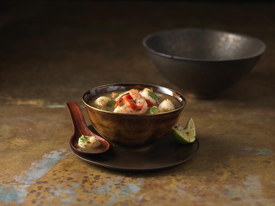 Bowl of tom yum soup with prawns, chilli and squeezed lime #1 Photograph by Diana Miller
