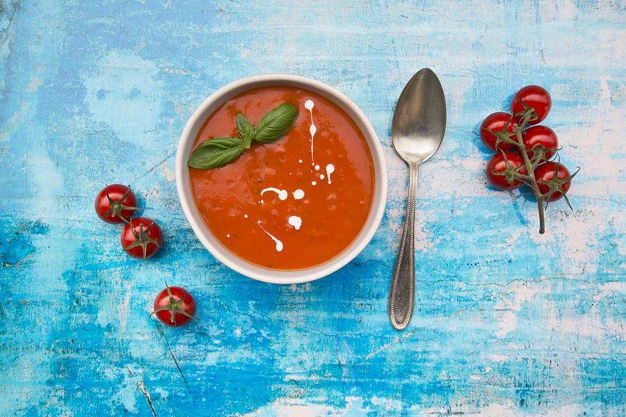 Bowl Of Tomato Soup On Blue Surface #1 Photograph by Larissa Veronesi