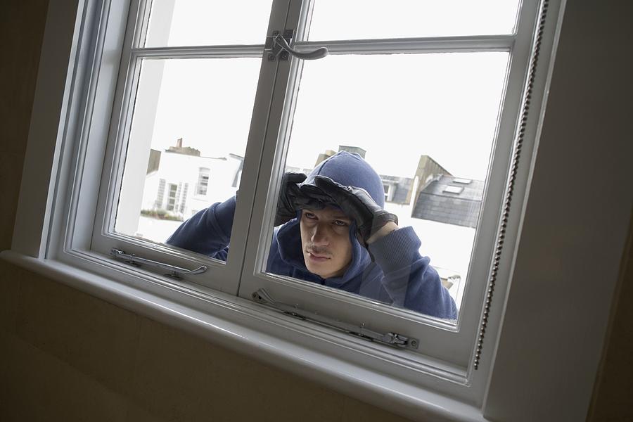 Burglar looking through window #1 Photograph by Image Source