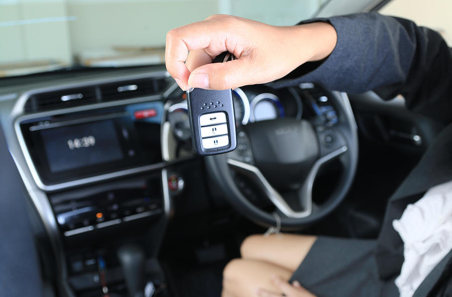 Business woman show remote key in modern vehicle car. #1 Photograph by Ko_orn