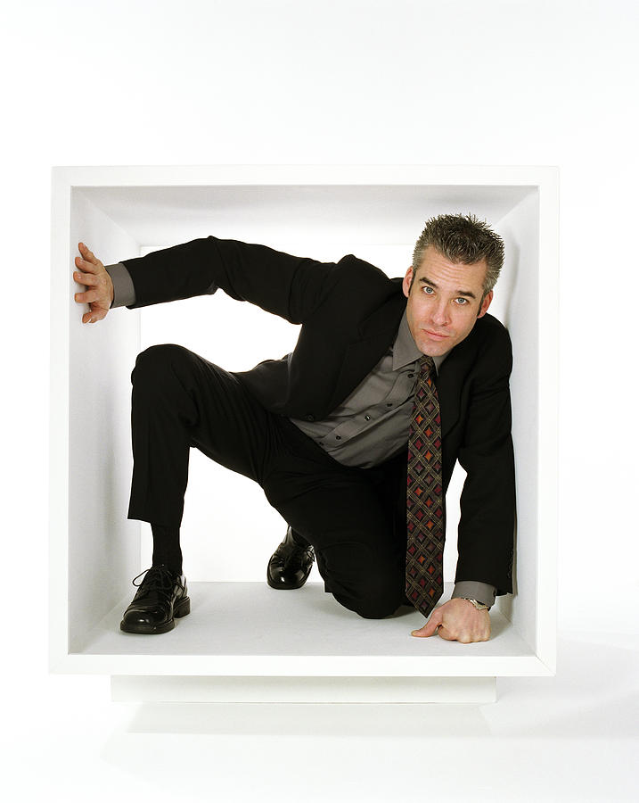 Businessman crouching within white box #1 Photograph by Kirk Weddle