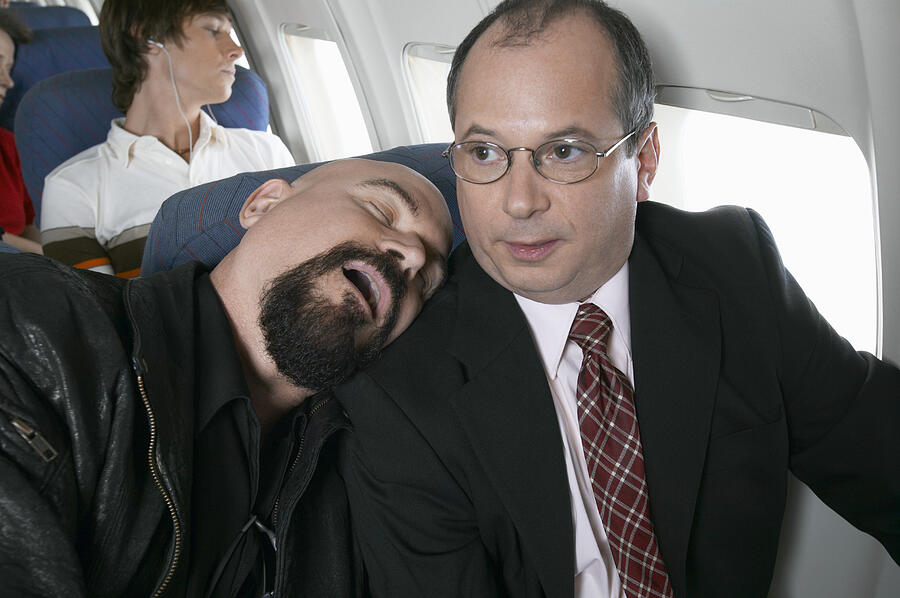 Businessman Sitting in an Aeroplane Trapped by a Man Sleeping by His Side #1 Photograph by Digital Vision.