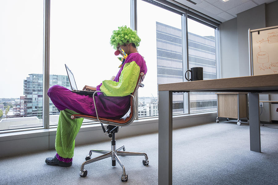 Caucasian businessman wearing clown costume in office #1 Photograph by Hill Street Studios