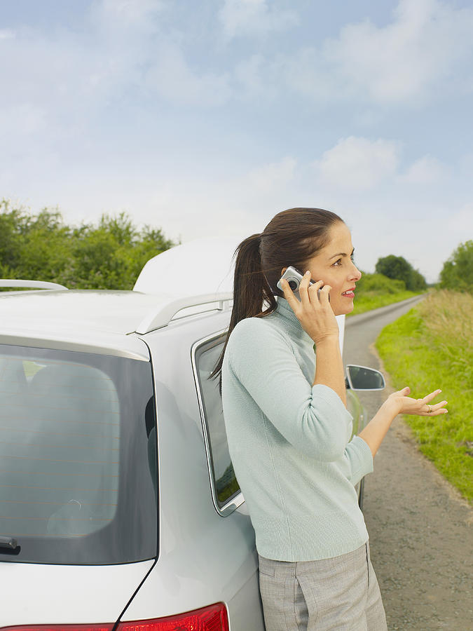 Caucasian businesswoman calling for help from broken down car on rural road #1 Photograph by Jacobs Stock Photography Ltd