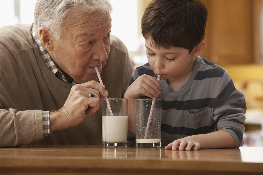Caucasian grandfather and grandson drinking milk together #1 Photograph by Jose Luis Pelaez Inc