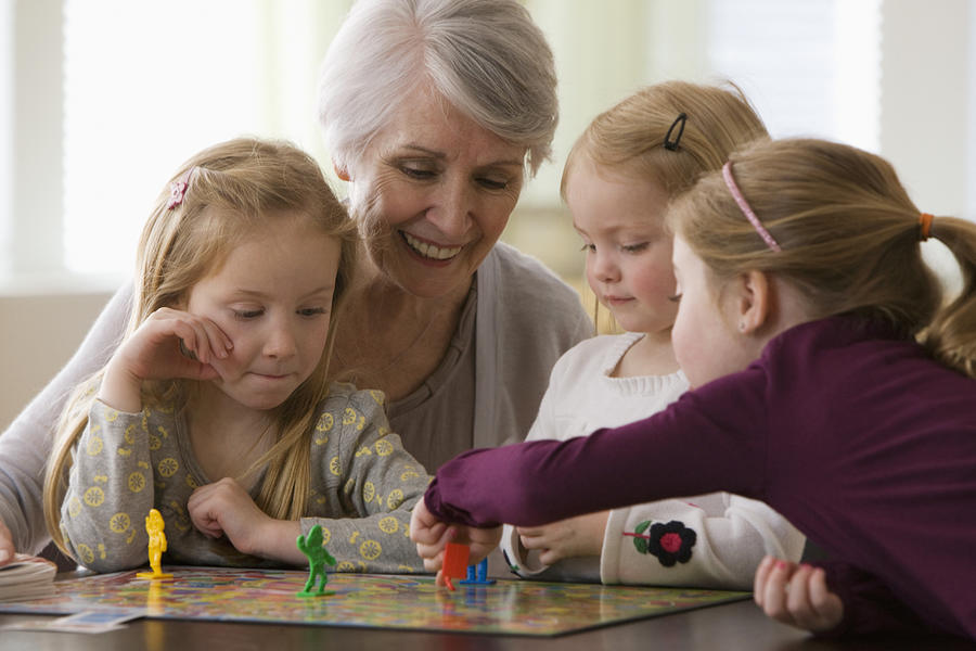 Caucasian grandmother and granddaughters playing game together #1 Photograph by Jose Luis Pelaez Inc