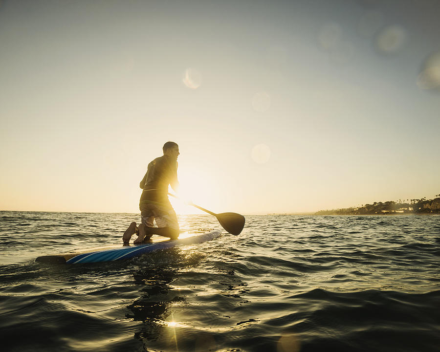 Caucasian man on paddle board in ocean #1 Photograph by Erik Isakson