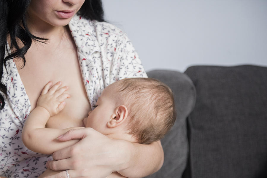 Caucasian mother breastfeeding baby son on sofa #1 Photograph by JGI/Jamie Grill