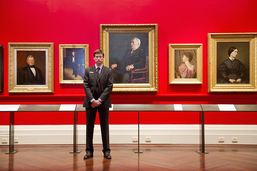 Caucasian security guard standing in art museum #1 Photograph by Jacobs Stock Photography Ltd