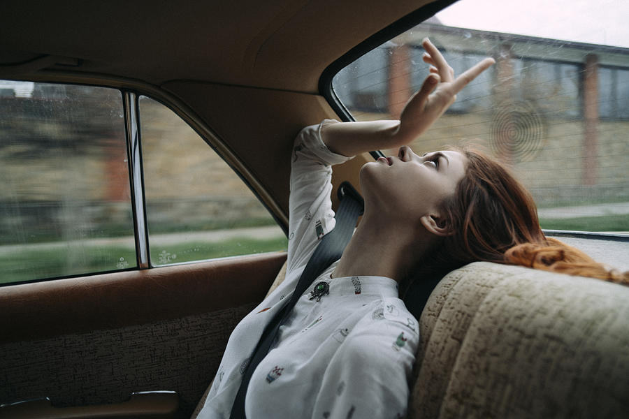 Caucasian woman in back seat of car looking up #1 Photograph by Dmitry Ageev