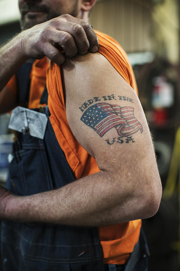 Caucasian worker displaying tattoo in factory #1 Photograph by Jetta Productions Inc