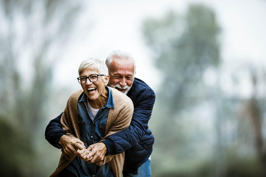 Cheerful senior couple having fun in the park. #1 Photograph by Skynesher