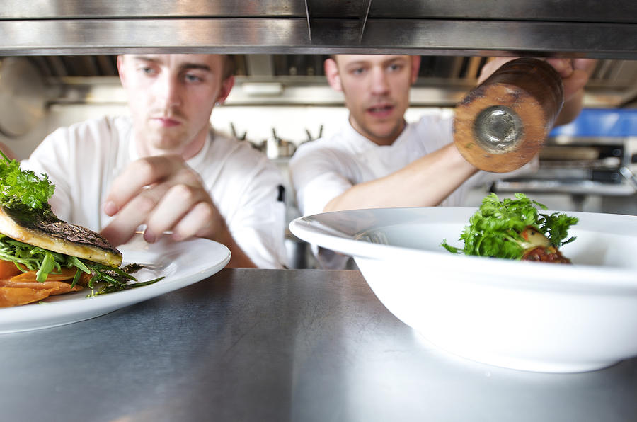 Chefs Doing Kitchen Preparation And Service  #1 Photograph by John Rensten