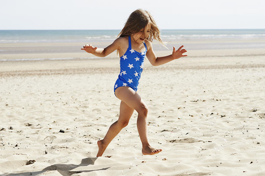 Child having fun at the beach #1 Photograph by Flashpop