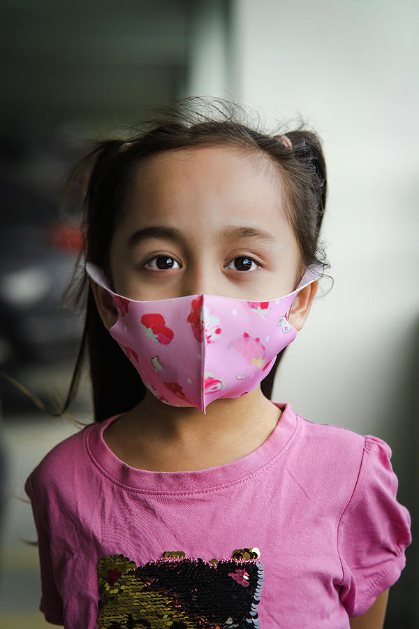 Child, little girl in a pink protective face mask, portrait, closeup ...