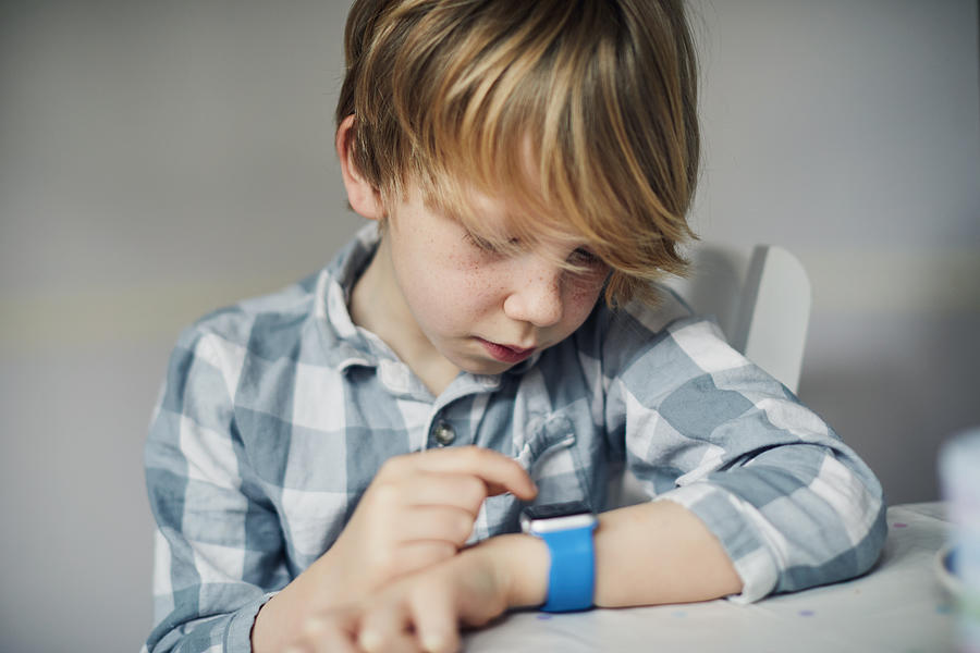 Child using a smart watch #1 Photograph by Sally Anscombe