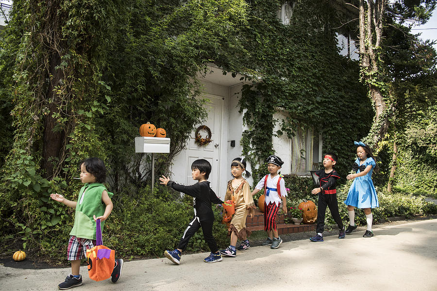 Children marching in front of the house wearing costumes. #1 Photograph by Kokouu
