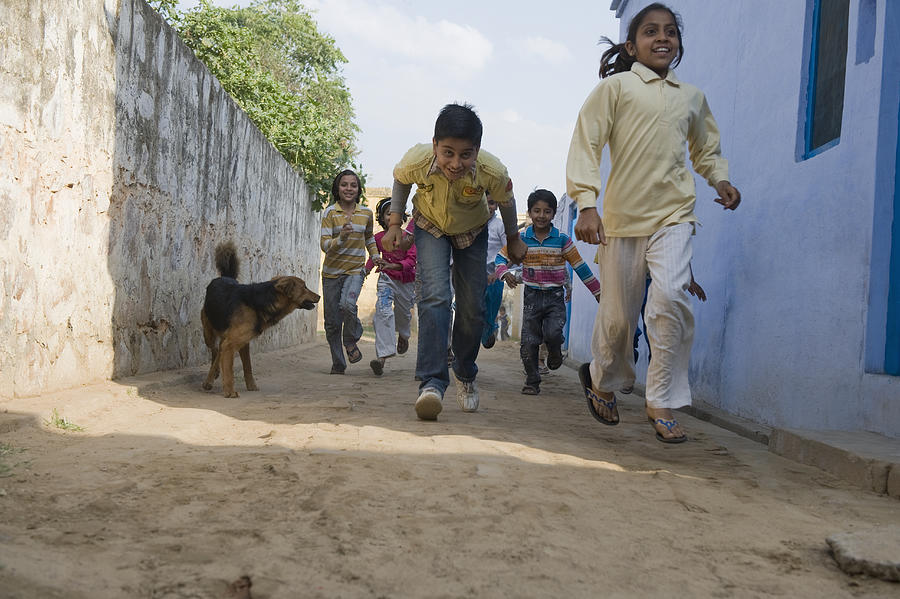 Children running in a street, Hasanpur, Haryana, India #1 Photograph by Uniquely India