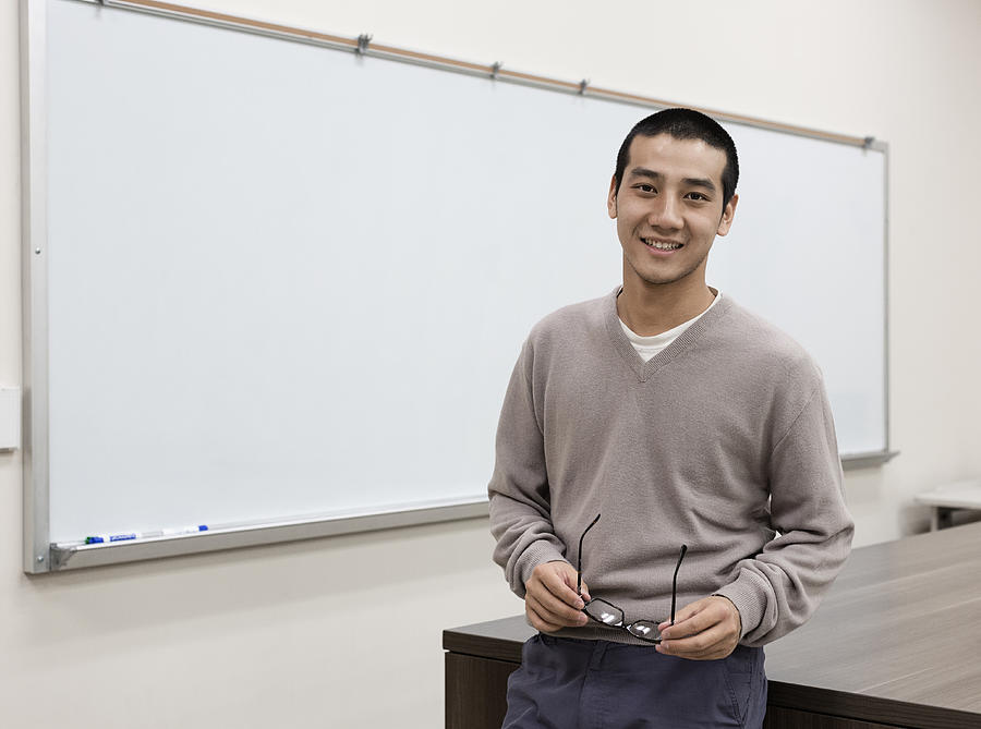 Chinese student standing at whiteboard in classroom #1 Photograph by Hill Street Studios