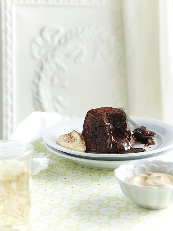 Chocolate fondant with gooey centre with cream on plate #1 Photograph by Brett Stevens