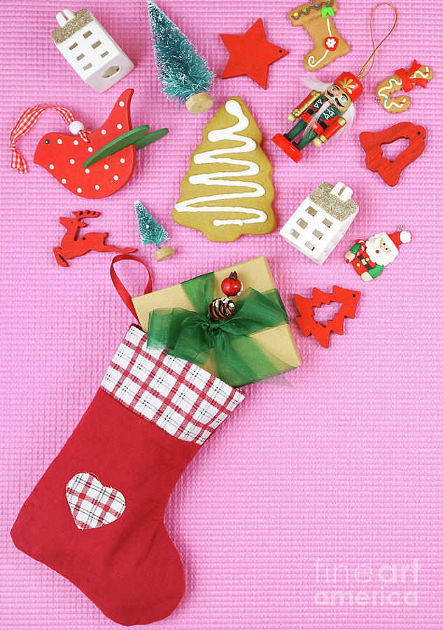 Christmas concept with stockings filled with gifts on a pink background. #1 Photograph by Milleflore Images