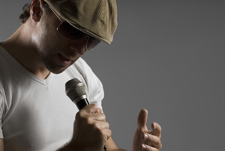 Close-up of a young man singing into a microphone #1 Photograph by Glowimages