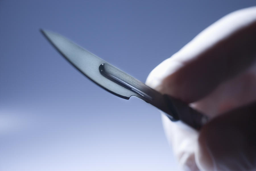Close up of Hispanic doctor holding surgical equipment #1 Photograph by REB Images