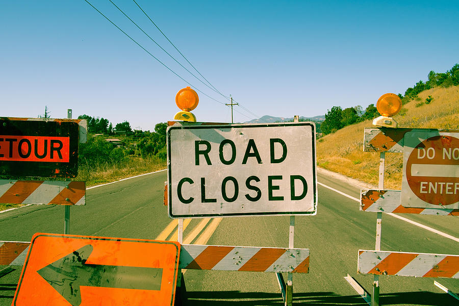 Close up row of road closed signs on highway #1 Photograph by Owen Smith