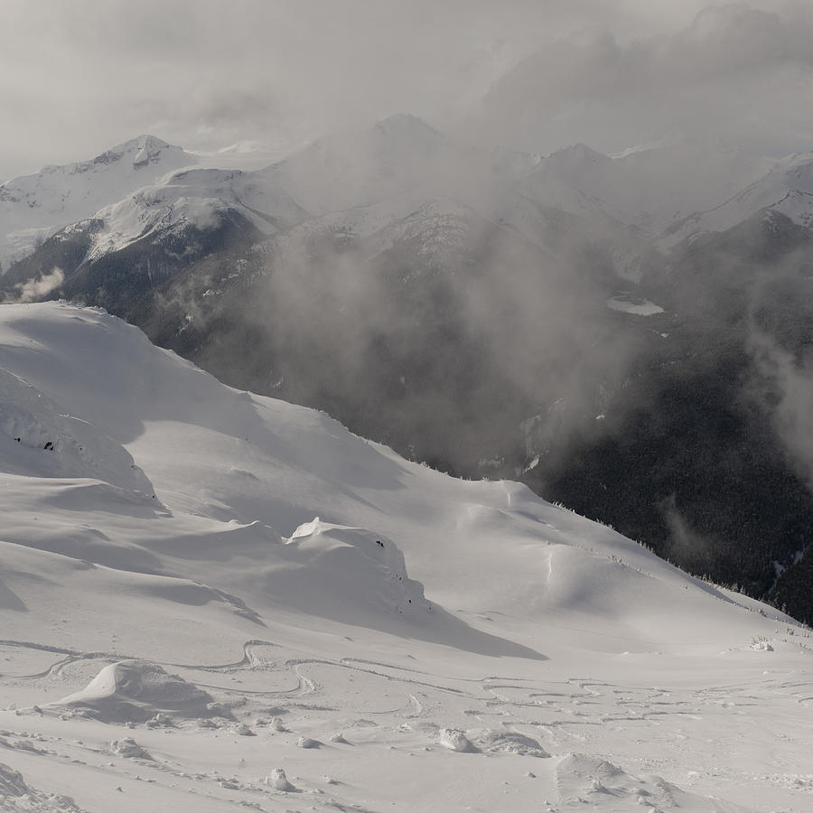 Clouds over snow covered mountains #1 Photograph by Fotosearch