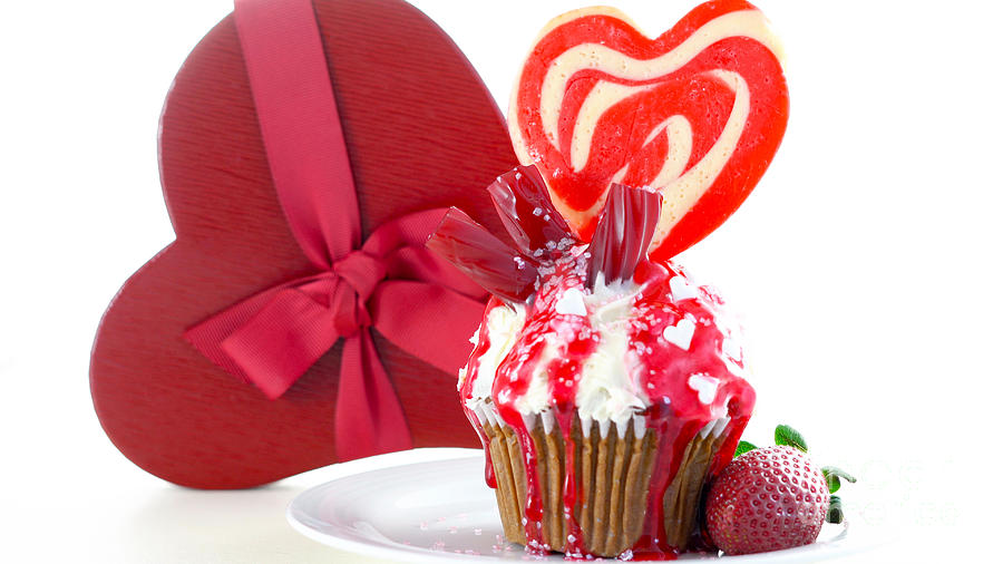 Colorful novelty cupcake decorated with candy and large heart shaped lollipop #1 Photograph by Milleflore Images