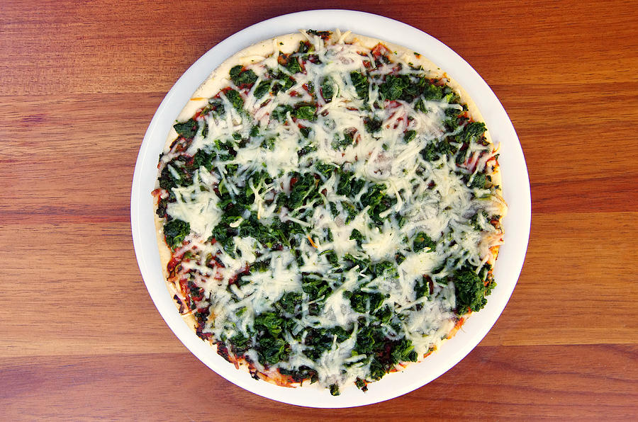 Cooked spinach and cheese frozen pizza #1 Photograph by Simon McGill