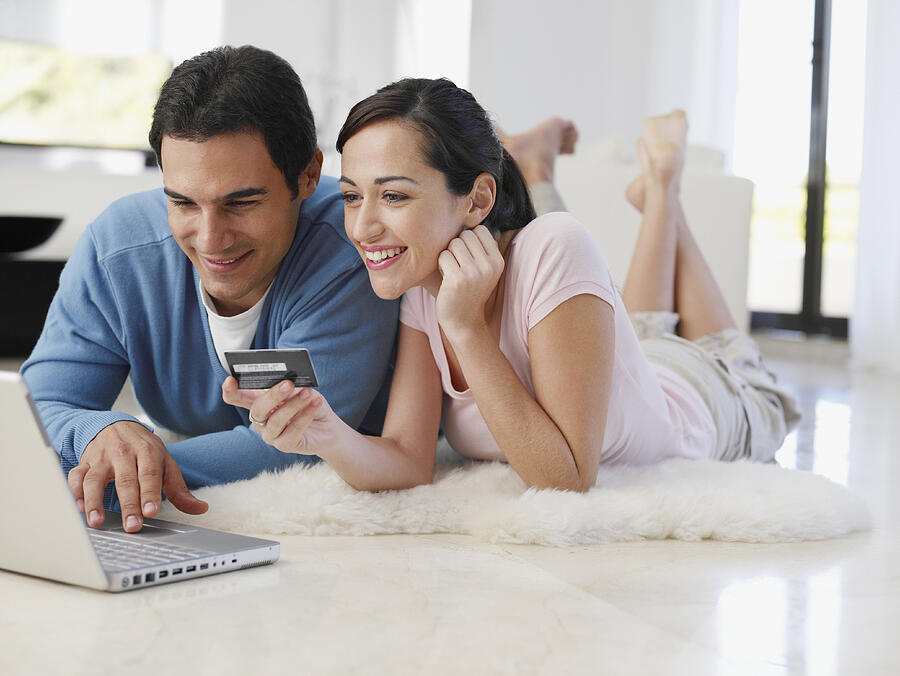 Couple lying on floor at home shopping online with credit card #1 Photograph by Chris Ryan