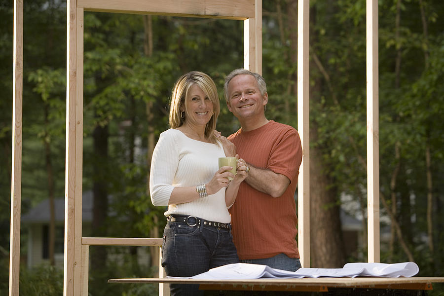 Couple reviewing blueprints at construction site #1 Photograph by Comstock Images