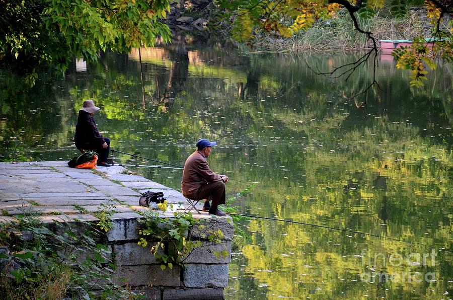 Couple sit quietly on jetty and fish at a lake outside Beijing China #2 Photograph by Imran Ahmed