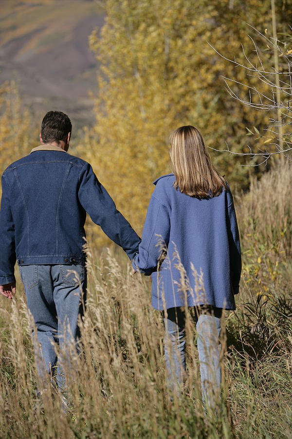 Couple walking in field #1 Photograph by Comstock Images